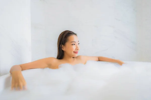 美しい若いアジアの女性の肖像画は バスルームのインテリアでバスタブでお楽しみください — ストック写真