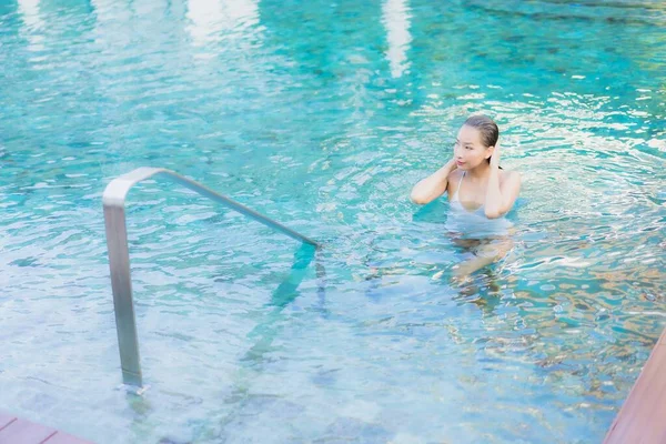 美丽动人的年轻亚洲女人在酒店度假胜地近岸的海滨游泳池边放松地笑着 — 图库照片
