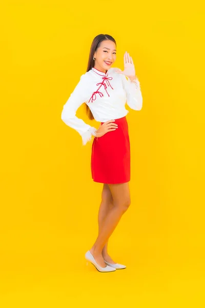 ポートレート美しい若いアジアの女性の笑顔アクションで黄色の背景 — ストック写真