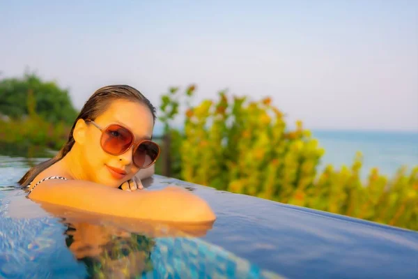 ポートレート美しい若いアジアの女性は休暇中にリゾートホテルでプールの周りのレジャーを楽しむ笑顔をリラックス — ストック写真