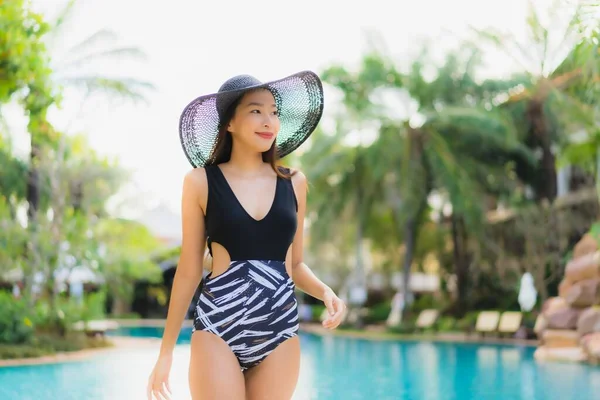 美丽动人的年轻亚洲女人快乐的笑着在酒店度假胜地的游泳池周围放松一下 — 图库照片
