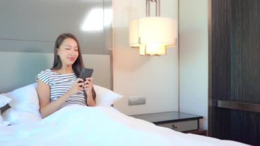 Güzel Asyalı kadının evde akıllı telefon kullandığının görüntüleri.