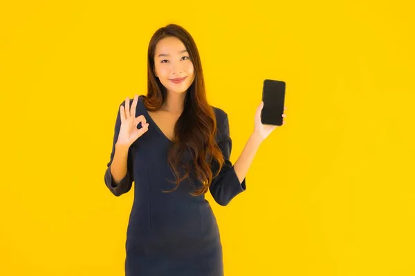Портрет Красивая Молодая Азиатская Женщина Смартфоном Сотовым Телефоном Желтом Изолированном — стоковое фото