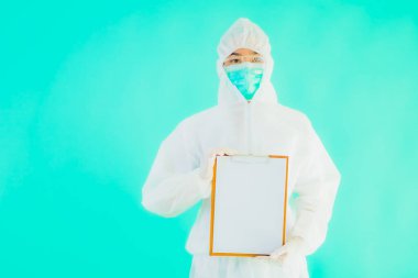 Güzel, genç Asyalı doktor kadın koronavirüsten korunmak için ppe ya da kişisel koruyucu ekipman takıyor ya da mavi izole arka planda beyaz kartı olan 19. bölgede yaşıyor.