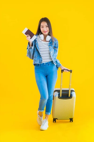 亚洲年轻貌美的女子 带着旅行袋和护照 独立的黄色背景下的登机证 旅行和休闲 — 图库照片