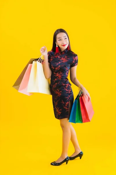 아름다운 아시아 여성의 초상화에는 쇼핑백 스마트폰 노랗게 고립된 배경을 가지고 — 스톡 사진