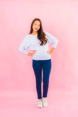 Portrait beautiful young asian woman smile with action on pink isolated background