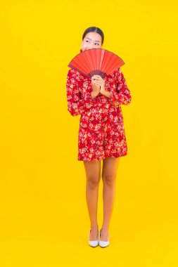 Güzel bir Asyalı kadının portresi Çin 'in yeni yıl konseptinde gülümsüyor. Renkli arka plan üzerine.