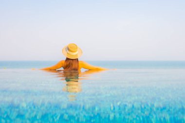 Güzel bir Asyalı kadın portresi. Rahatlayın, gülümseyin. Tatil için oteldeki yüzme havuzunun keyfini çıkarın.