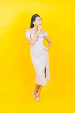 Portre güzel Asyalı kadın gülümsüyor. Renkli arka planda hareket var.