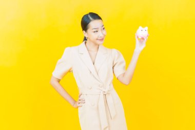 Renkli arka planda domuz kumbarası olan güzel Asyalı kadın portresi