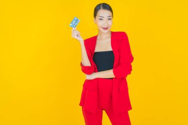 Güzel bir Asyalı kadının portresi. Renkli kredi kartıyla gülüyor.