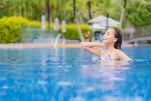 美丽动人的年轻亚洲女人度假时 在酒店度假胜地的室外游泳池边 放松地笑个好觉 — 图库照片