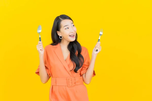 Asyalı Güzel Bir Kadının Portresi Sarı Arka Planda Çatal Kaşıkla — Stok fotoğraf