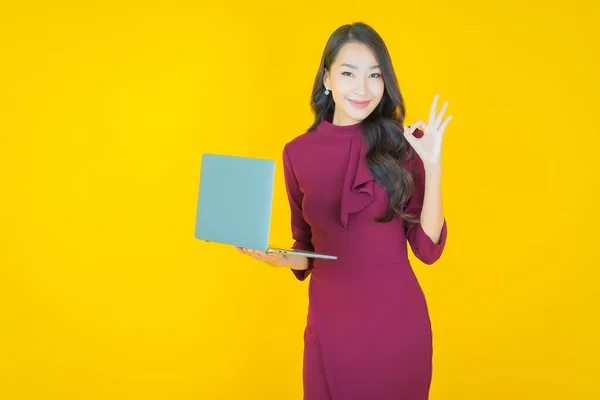 아름다운 아시아 여성의 초상화외진 배경에 컴퓨터 랩탑을 미소짓는 — 스톡 사진