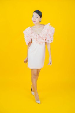 Portre güzel Asyalı kadın gülümsüyor. Renkli arka planda hareket var.