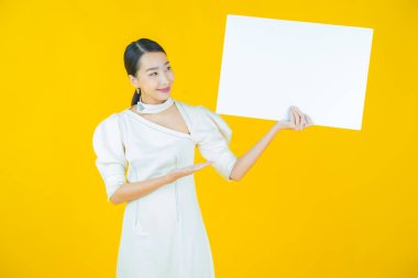 Renkli arka planda boş beyaz ilan panosu olan güzel Asyalı kadın portresi