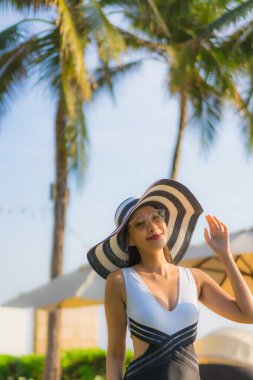 Güzel bir portre genç Asyalı mutlu bir gülümseme tatil beldesi otelinde havuzda rahatça yüzebiliyor.