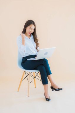 Güzel bir iş kadını portresi. Sandalyeye dizüstü bilgisayarı ya da iş için akıllı telefonu olan bir kadın.