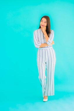 Asyalı güzel bir kadının portresi mavi izole edilmiş arka planda gülümsüyor.