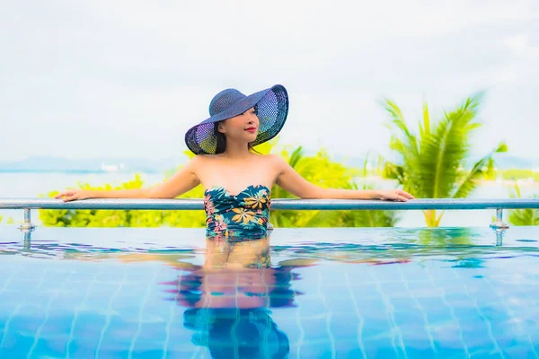 美しい若いアジアの女性の肖像旅行休暇のための海の景色を屋外スイミングプールの周りの笑顔のレジャーをリラックス — ストック写真