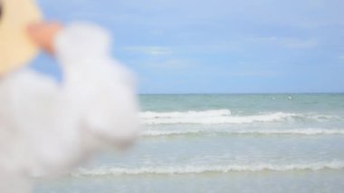 Yaz tatilinde deniz kıyısındaki Asyalı kadının görüntüleri.