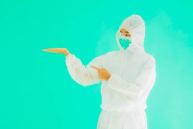 Güzel, genç Asyalı doktor kadın portre. Koronavirüsten ya da mavi arka planda kovid19 'dan korunmak için ppe ya da kişisel koruyucu ekipman takıyor.