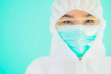 Güzel, genç Asyalı doktor kadın portre. Koronavirüsten ya da mavi arka planda kovid19 'dan korunmak için ppe ya da kişisel koruyucu ekipman takıyor.