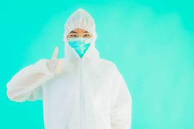 Güzel, genç Asyalı doktor kadın portre. Koronavirüsten ya da mavi arka planda kovid19 'dan korunmak için ppe ya da kişisel koruyucu ekipman takıyor.