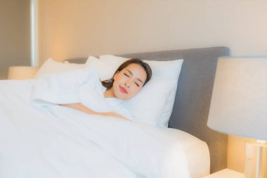 Asyalı güzel bir kadının portresi. Gülümse. Yatak odasında rahatla.