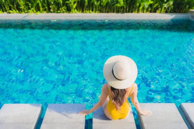 Güzel bir Asyalı kadın portresi. Rahatlayın. Keyifli bir tatil için oteldeki yüzme havuzunda mutlu bir gülümseme.