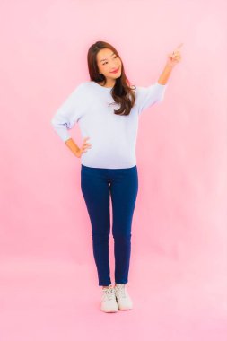 Portrait beautiful young asian woman smile with action on pink isolated background