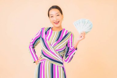 Parası, parası ve cep telefonu olan güzel Asyalı bir kadının portresi.