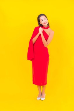 Güzel bir Asyalı kadın portresi. Sarı izole edilmiş arka planda hareketli gülümsüyor.