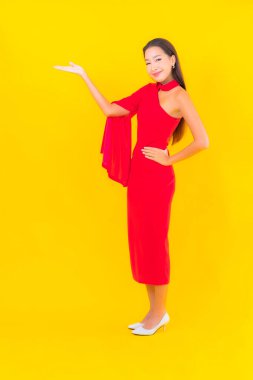 Güzel bir Asyalı kadın portresi. Sarı izole edilmiş arka planda hareketli gülümsüyor.