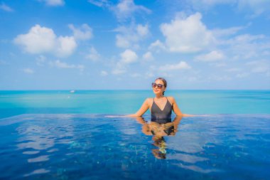 Güzel bir Asyalı kadın portresi. Rahatlayın. Okyanus manzaralı, tatil köyündeki yüzme havuzunda rahatlayın.
