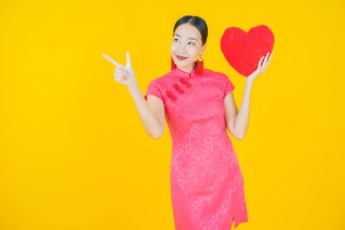 Portre güzel Asyalı genç kadın gülümsüyor kalp yastığı şeklinde renk arkaplan