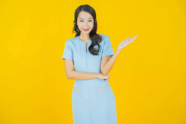 黄色の色の背景にコールセンターカスタマーケアサービスセンターと肖像美しい若いアジアの女性 — ストック写真