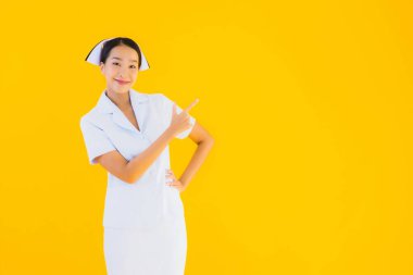 Güzel Asyalı genç Taylandlı hemşirenin portresi klinikteki ve hastanedeki hastalar için sarı izole edilmiş arka planda birçok eylem çalışmasında yer alıyor.