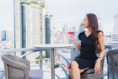 Güzel bir Asyalı kadın portresi. Kokteyllerle eğleniyor. Barda ve restoranda bardak içiyor.