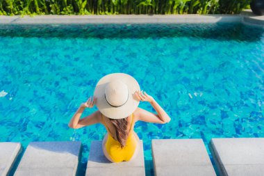 Güzel bir Asyalı kadın portresi. Rahatlayın. Keyifli bir tatil için oteldeki yüzme havuzunda mutlu bir gülümseme.