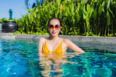 Güzel bir Asyalı kadın portresi. Rahatlayın. Keyifli bir tatil için oteldeki yüzme havuzunda mutlu bir gülümseme.