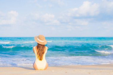 Güzel bir Asyalı kadının portresi. Rahatlayın. Plaj okyanusunda tatil yaparken gülümseyin.