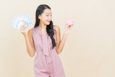 Renkli arka planda domuz kumbarası olan güzel Asyalı kadın portresi