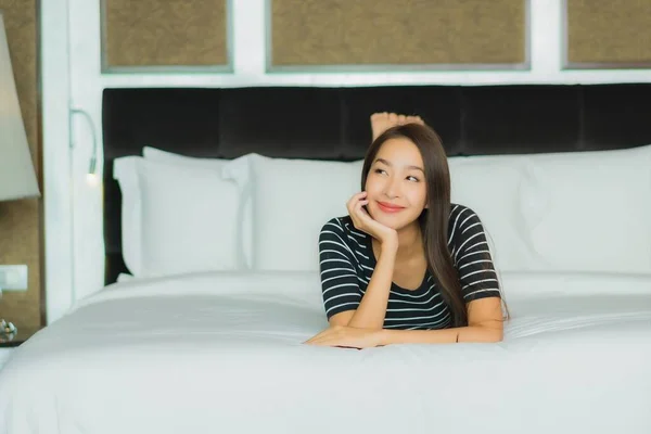 아름다운 아시아인 여인의 미소는 침실의 위에서 편안하게 흐른다 — 스톡 사진