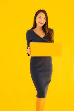 Karton paketli güzel Asyalı kadın, sarı izole edilmiş arka planda nakliyeye hazır.
