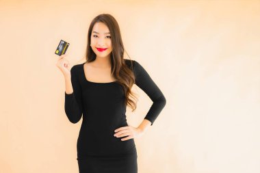 Renkli arka planda alışveriş yapmak için kredi kartı olan güzel bir Asyalı kadın portresi.