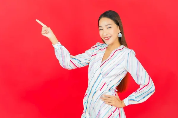 ポートレート美しい若いアジアの女性の笑顔ともに多くのアクション上の赤い背景 — ストック写真