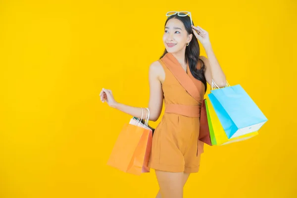 亚洲年轻貌美的女人带着色彩艳丽的购物袋微笑 — 图库照片