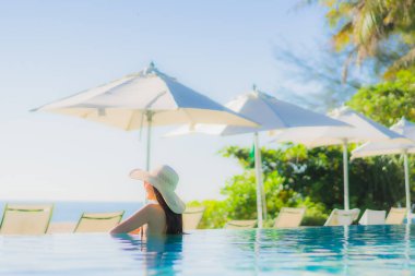 Güzel bir Asyalı kadın portresi. Mutlu bir gülümseme. Keyifli bir tatil için otel havuzunda rahatça yüzme havuzu.